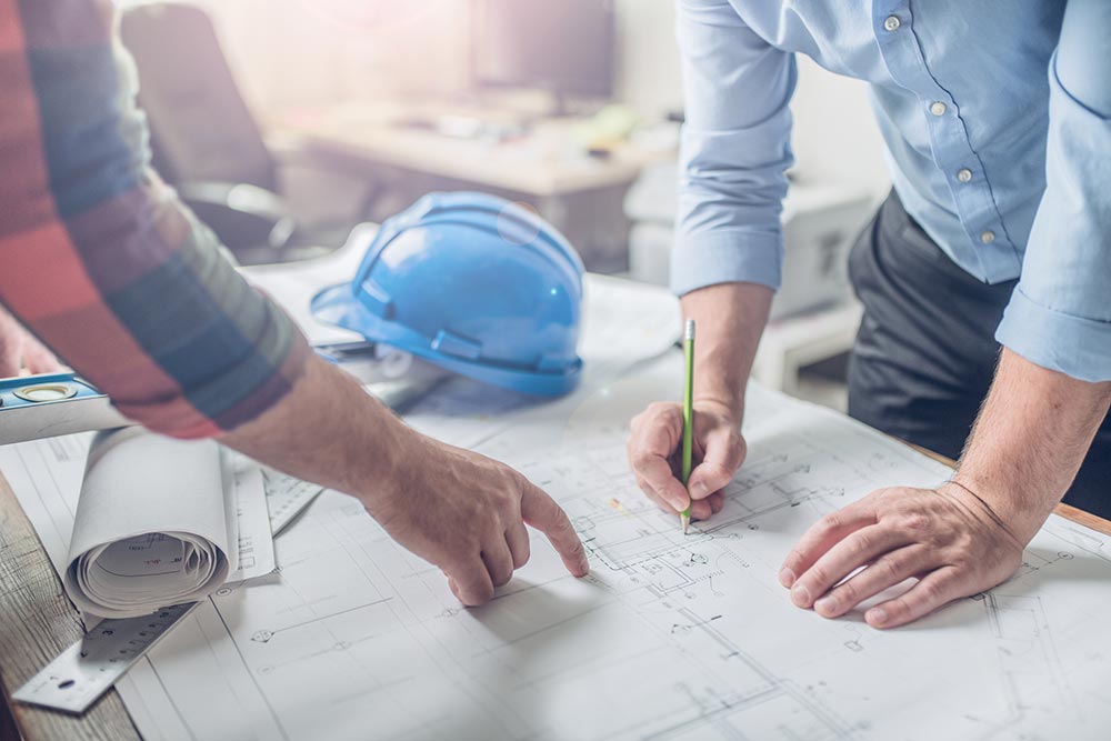 two people working on construction plans